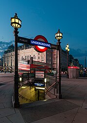 English: West entrance to the Piccadilly Circus tube station, early morning, blurred London bus in the background.