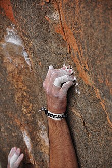 Hand hält ein Lineal mit gewölbten Fingern