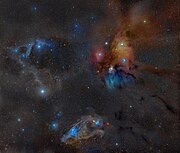 The large multicoloured Rho Ophiuchi cloud complex with the Dark River clouds (or Rho Ophiuchi Streamers) as Barnard 44 and 45 on the right, seemingly radiating towards the distant Pipe Nebula and the Galactic Center, extending from the core L1688 as well as L1689 dark nebulae.[6] In the lower part of this wide field image the distinct blue eyed (Nu Scorpii) Blue Horsehead Nebula can be seen. The blue area at the back of the head is IC 4601. The cloud in the top left corner is LBN 1093 and Sh2-1 with the bright star being Pi Scorpii and the yellowish cloud in the middle on the left being Sh2-7 with Dschubba at its center.