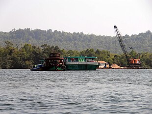 A sand mining boat dredges Cambodia's Tatai River. Sandmining tatai river 2012.jpg