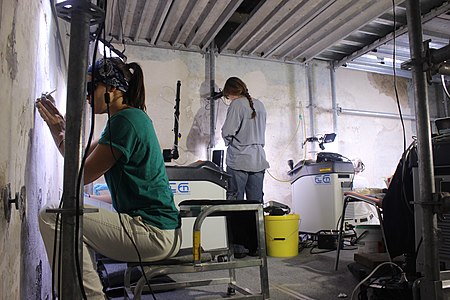 Technicians at work using laser scraping techniques in the sala delle asse