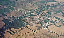 Veduta aerea del centro abitato con la grande macchia verde della ZPS le Marice, sulla sinistra.