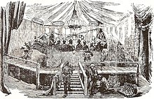 Dîner à l'iguanodon qui a lieu le 31 décembre 1853. Organisé par Benjamin Waterhouse Hawkins dans le ventre d'un moule d'un iguanodon préhistorique, il est destiné à lancer l'exposition des dinosaures de Crystal Palace[alpha 3].