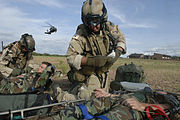 担架に乗った兵士に応急処置を施すアメリカ空軍のパラジャンパー