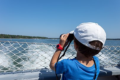 Gabriel aboard the Tricia Clark with a set of binoculars, Maine Coastal Islands National Wildlife Refuge, Maine, US