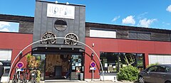 Fachada de un edificio comercial con el cartel Hop'la encima de la puerta.