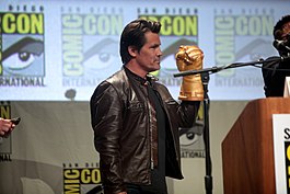 Josh Brolin posing with an Infinity Gauntlet prop while promoting the films at the 2014 San Diego Comic-Con