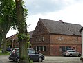 North-eastern farmhouse and attached side building with an angled floor plan with a four-sided courtyard through a gate on the street