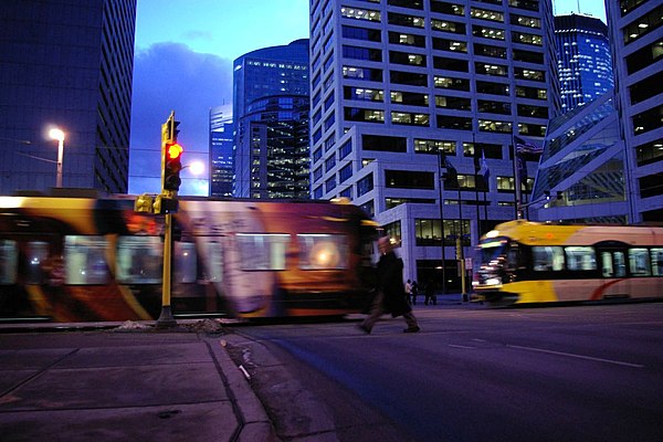 A pedestrian walking next to moving trains