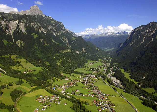 Luftbild der Gemeinde Innerbraz von Westen aus gesehen; links unten Brazer Bogen der am linken Talhang bergauf ziehenden Arlbergbahn; rechts S16; links oben Roggelskopf