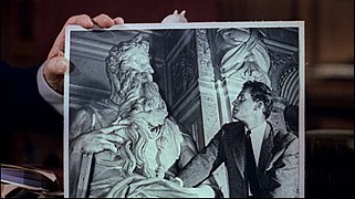 Cecil B. DeMille tenant une photo de Charlton Heston en train de regarder le Moïse de Michel-Ange. La ressemblance de l'acteur avec la sculpture l'a aidé à obtenir le rôle de Moïse[7].