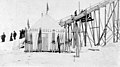 Nome Ski Club tent with skis lined up, ski lift, and line of people, vicnity of Nome, Alaska, between 1900 and 1920 (AL+CA 6333).jpg