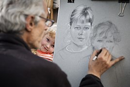 An artist doing the portrait of a child in Montmartre, Paris