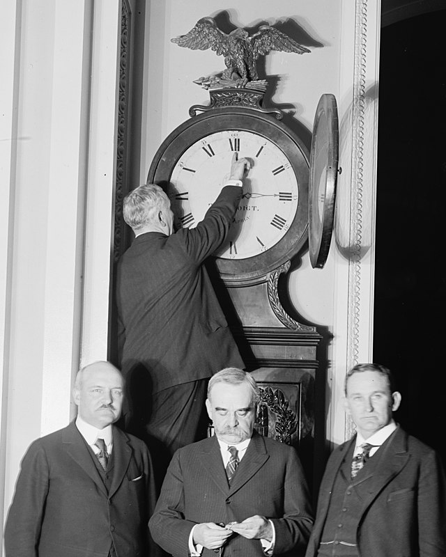 https://upload.wikimedia.org/wikipedia/commons/thumb/9/99/Senate_Sergeant_at_Arms_Charles_Higgins_turns_forward_the_Ohio_Clock_for_the_first_Daylight_Saving_Time%2C_while_Senators_William_Calder_%28NY%29%2C_William_Saulsbury%2C_Jr._%28DE%29%2C_and_Joseph_T._LOC_hec.13949_%28cropped%29.jpg/640px-thumbnail.jpg