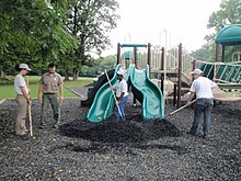 Rubber mulch being installed at a playground Spreading Rubber Mulch on Playground.jpg