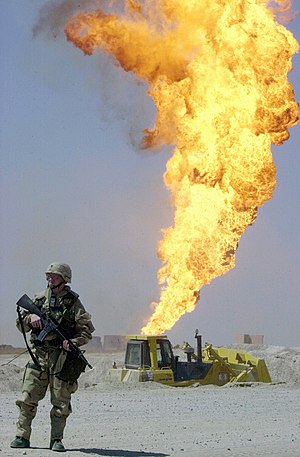 US Navy 030402-N-5362A-010 A U.S. Army soldier stands guard duty near a burning oil well in the Rumaylah Oil Fields.jpg