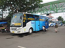 Unit bus kota trayek E1 milik Perum DAMRI cabang Surabaya berbodi Trisakti Mini Titan GX dan sasis Mercedes-Benz OF1113 terparkir di peron bus Terminal Joyoboyo, 15 Januari 2014.jpg