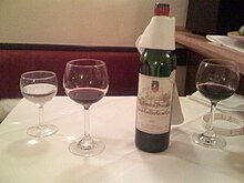 Wine bottle with drip cloth around it Wine serving at restaurant with drip cloth.jpg