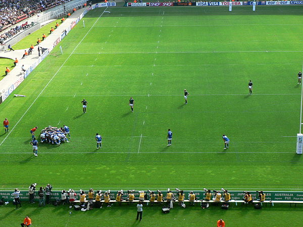 The forwards are in the scrum while the backs are lined up across the field.