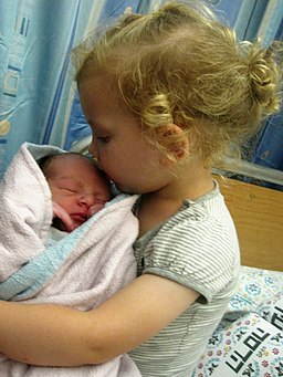 A 3-year-old embraces her brother less than a day after he was born
