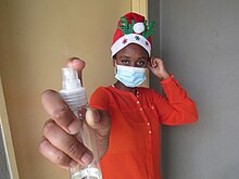 African girl with mask and sanitizer.jpg