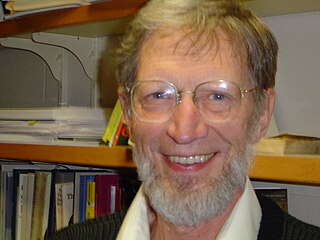 The head of a smiling, bespectacled, and bearded man in his seventies.