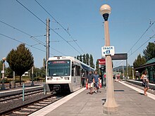 Passengers alighting from a Red Line train at the center platform of Beaverton Transit Center