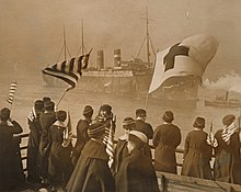 Women in American Red Cross uniform by the North River in New York on 16 January 1919, waving US and Red Cross flags to greet 3,627 troops aboard Belgic as she comes into port.
The ship is as completed in 1917, with two funnels and three masts. White Star Line is operating her, but her funnels seem to be in Red Star Line colours of black with a white band. Belgic North River 1919-01-16 NARA - 26433767.jpg