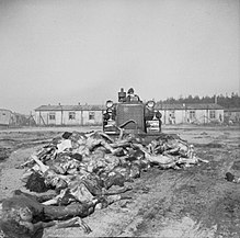 A British Army bulldozer pushes bodies into a mass grave at Belsen, 19 April 1945 Bergen Belsen Liberation 03.jpg