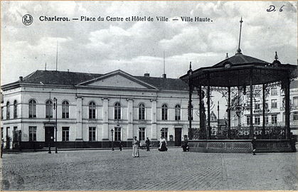 Ancienne carte postale en noir et blanc avec un bâtiment néo-classic devant lequel se dresse un kiosque.