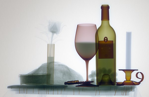 Natural color X-ray photogram of a wine scene. Note the edges of hollow cylinders as compared to the solid candle.