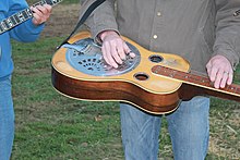 Dobro guitar - Dobro guitar played standing. Note the height of strings off fretboard. Dobro guitar - Bluegrass Band, Kentucky (2011-10-16 by Navin75).jpg