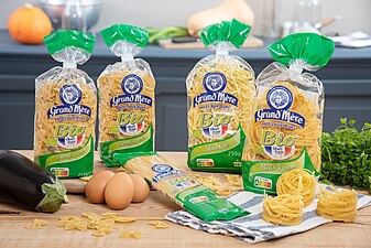 Fotografía que muestra paquetes de pasta estampados "Grand'Mère" y "Bio" en medio de otros productos alimenticios.