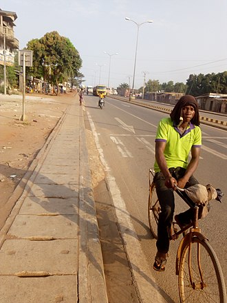 Man cycling on Akassato-Calavi road HOMME SUR velo.jpg