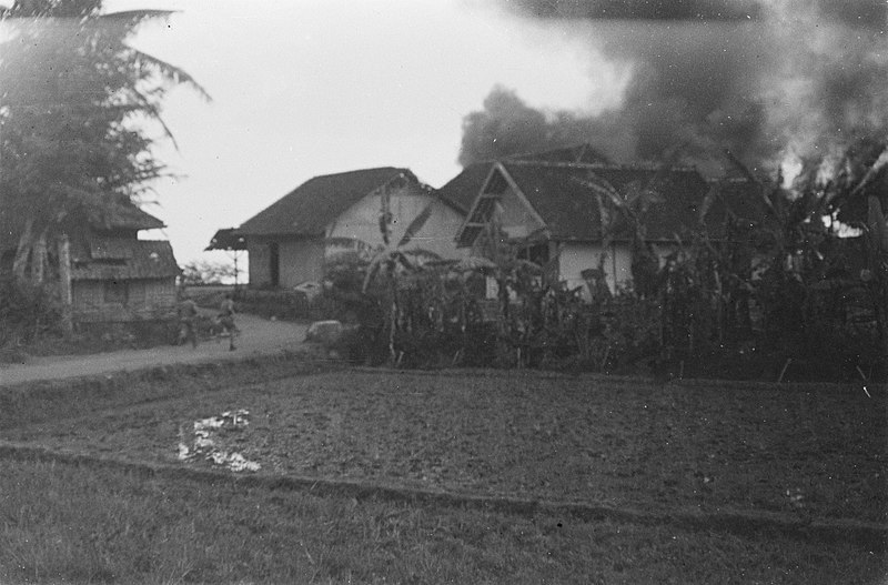 File:Militairen rennen in een kampong, waar een aantal huizen in brand staan, Bestanddeelnr 39-4-6.jpg