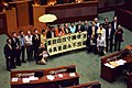 泛民主派議員在政改方案被否決後，到會議廳內主席台前展示標語