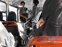 Busker on a Jakarta bus Pengamen di bus.jpg