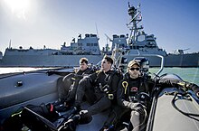 Petty officer divers in a rigid-hull inflatable boat Petty Officers ride in a rigid-hull inflatable boat as they approach the USS Mason. (31494897982).jpg