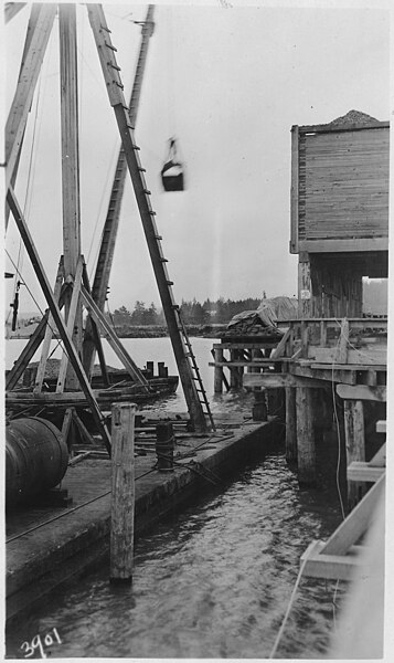 File:Rock bunkers and Lewis & Clark River, and clam shell unloading barge. - NARA - 298262.jpg