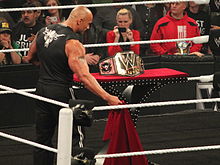 The Rock unveiling the "Big Logo" (2013-2014) version of the WWE Championship Rock revealed his title.jpg
