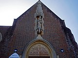 The sculpture of St Augustine which sits in a large niche above an inscription over the main entrance was designed by John Skelton (1923–1999).