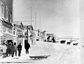 Snow covered storefronts and street showing a group of men standing by a dog sled team, Teller, Alaska, circa 1907 (AL+CA 2416).jpg