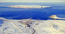 Aerial photograph, land masses are covered in snow, but the bay is not frozen over