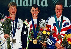 Tracey Cross 100 метр қашықтықта басқа medallists.jpg-мен ұшады