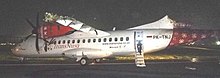 PK-TNJ, the aircraft being towed on the runway, seen after the collision. TransNusa Aviation Mandiri PK-TNJ wreckage.jpg