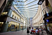 VPL Central branch internal glass facade overlooks an enclosed concourse formed by an elliptical wall. Vancouver Public Central Library (36907920883).jpg