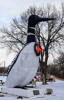 Escultura de hormigón de 20 pies de alto de un pájaro blanco y negro