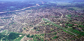 Luftbild, links hinten der Río Pirai, rechts vorne die Landebahn des Flughafens El Trompillo