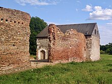 The ruins of Woking Palace in 2023. The stone building is an original part of the palace, but the brick walls are part of a 16th-century barn. Woking Palace, Old Woking, Surrey 01.jpg