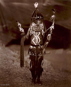 Navajo man in ceremonial dress with mask and body paint, c. 1904